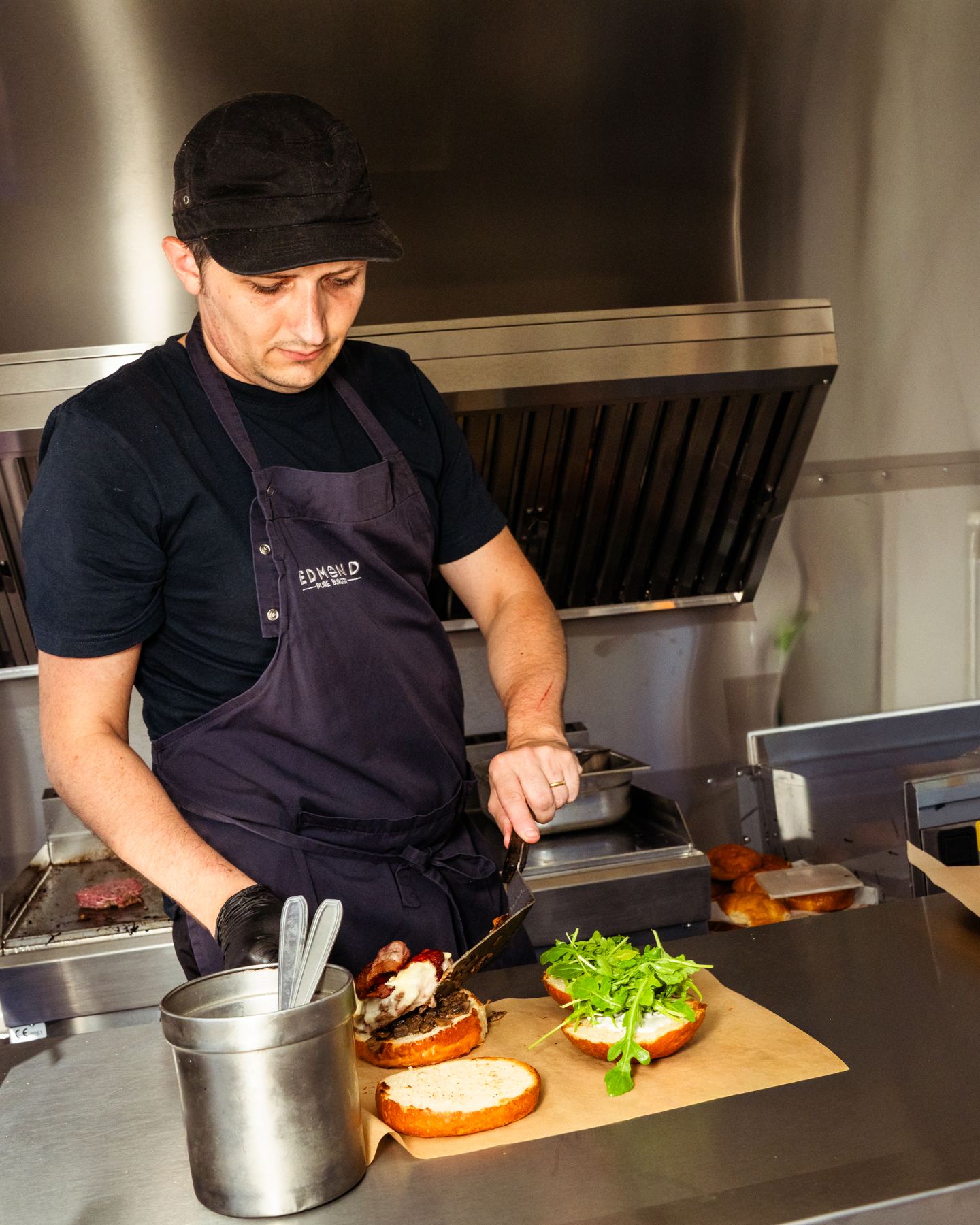 Un cuisinier devant sa plancha dans une remorque food truck